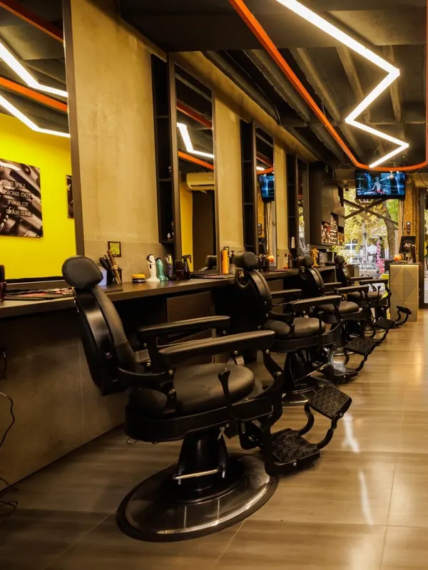 Barber chairs lined up along the mirrors and the yellow wall
