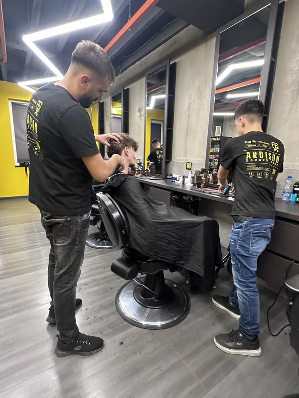 Two Ardison barbers cutting hair at their stations