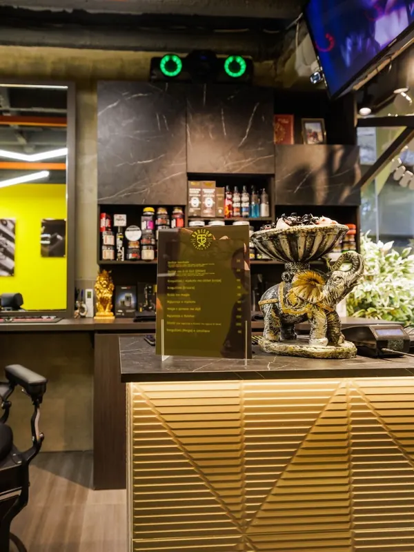 The gold-lit front desk with grooming products on the shelves