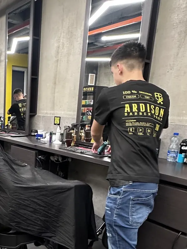 An Ardison barber with a fresh skin fade working at his station