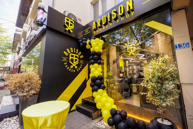 The Ardison Barber Shop front by day, black with yellow lettering