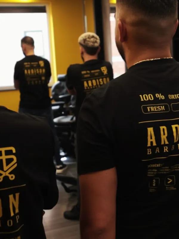 Ardison barbers in their black team shirts, in black and white